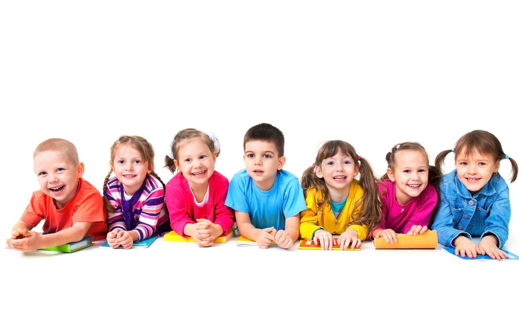 16035874 – group of seven children are lying on floor with copybooks together